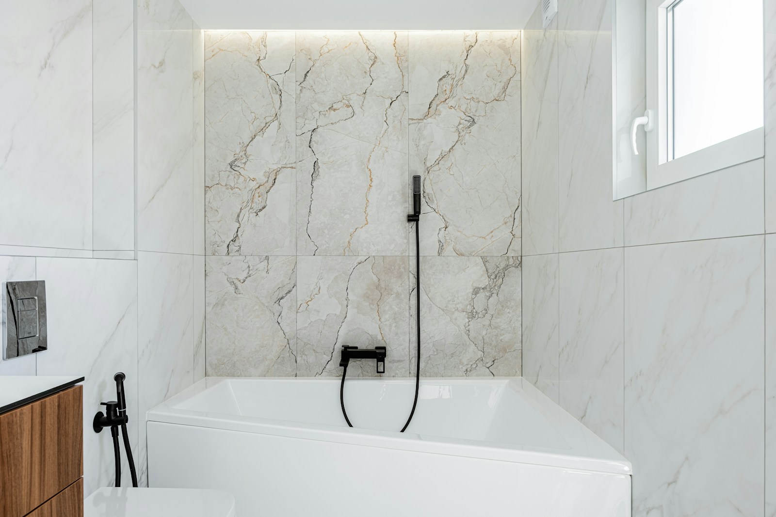 Modern bathroom with white marble and bathtub.
